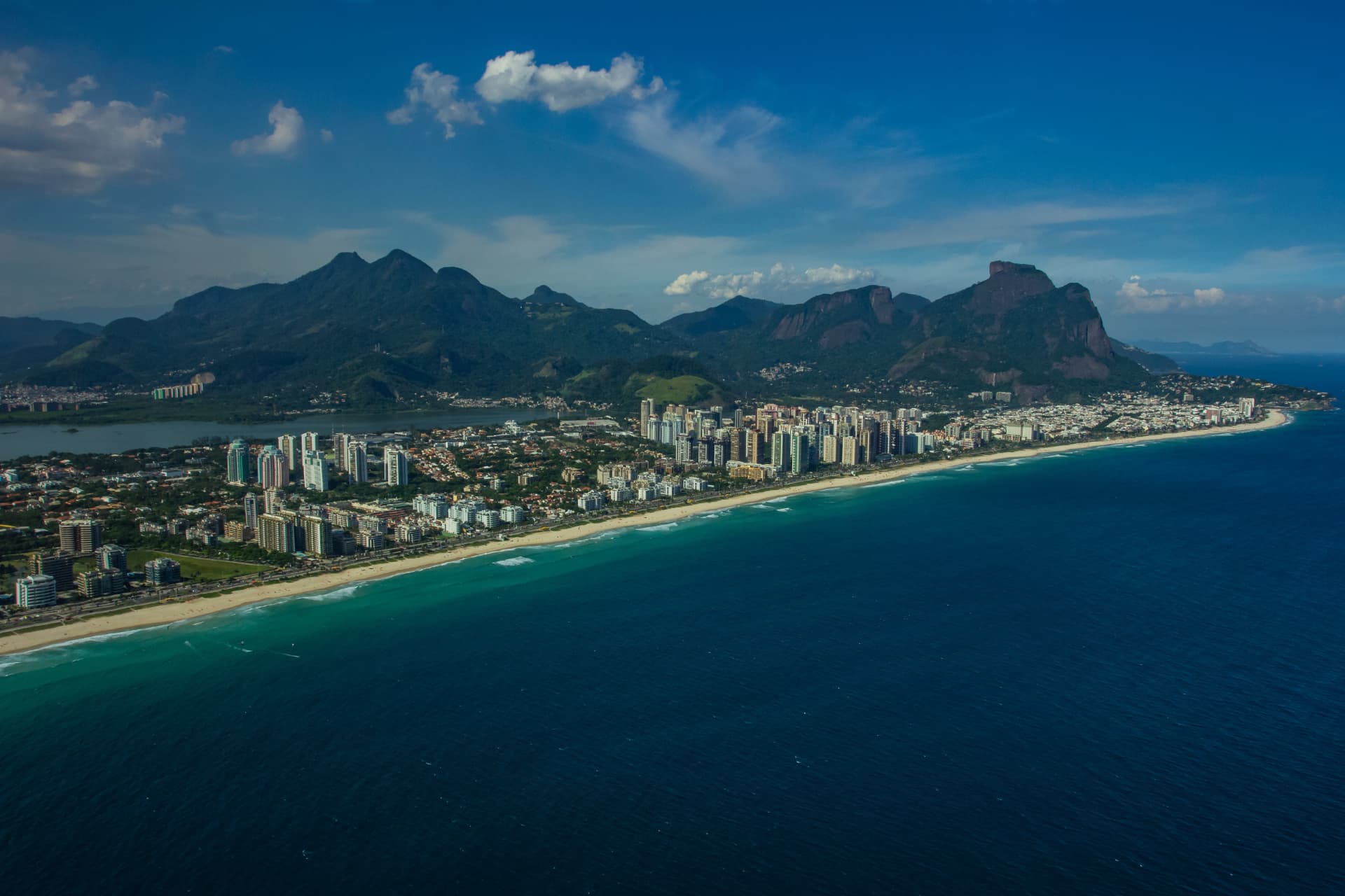 Vista aérea da Barra da Tijuca com praia, canal e Pedra da Gávea ao fundo